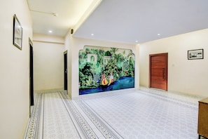 Un pasillo con un mural, una puerta de madera y suelo estampado.