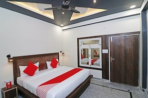 A hotel room with a bed, a ceiling fan, a wardrobe, and a mirror. - HOTEL O 03 TOWN HOUSE Shaheed Captain (Agra)