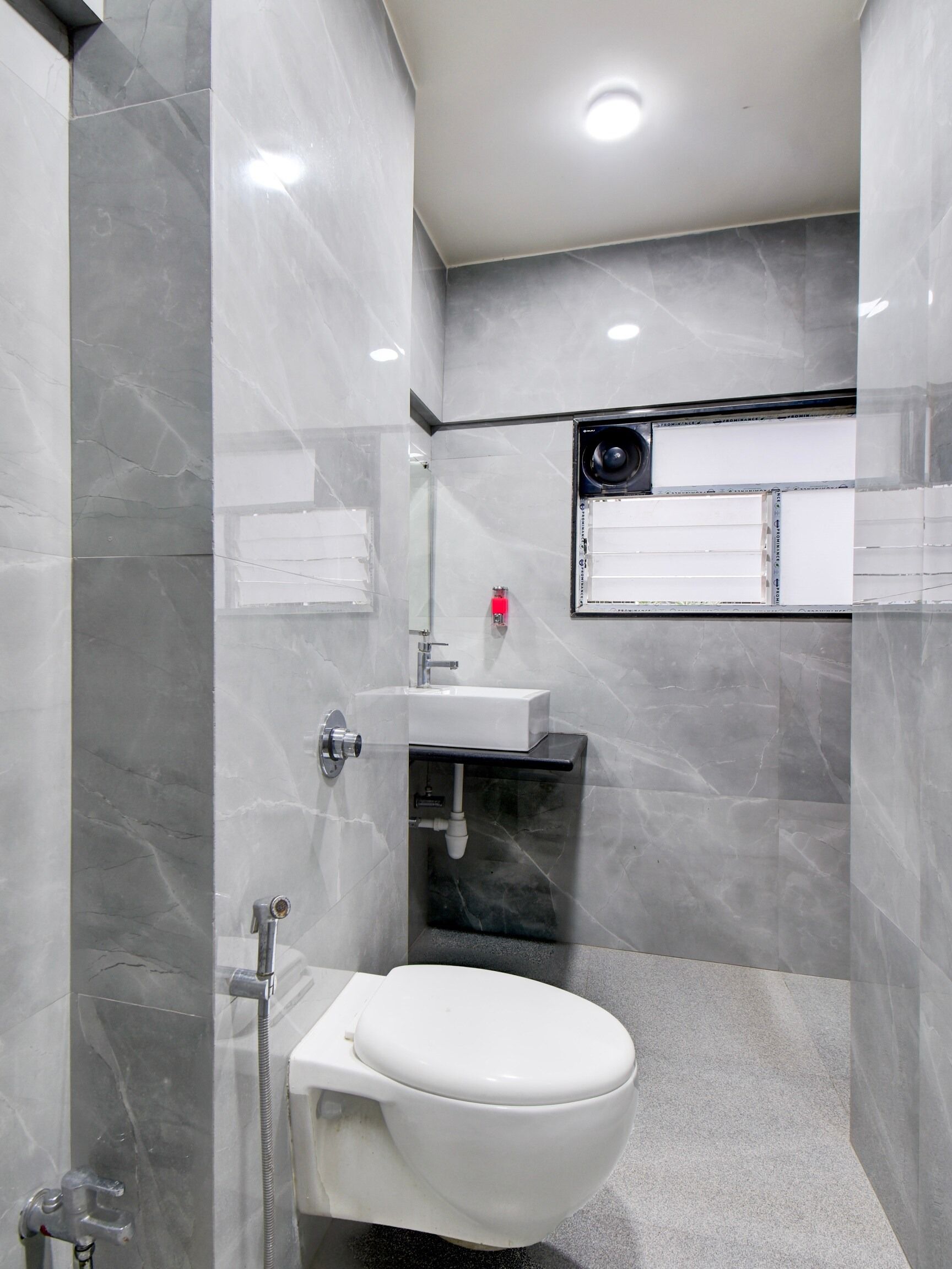 A modern bathroom with a white toilet, a sink, and a shower area.