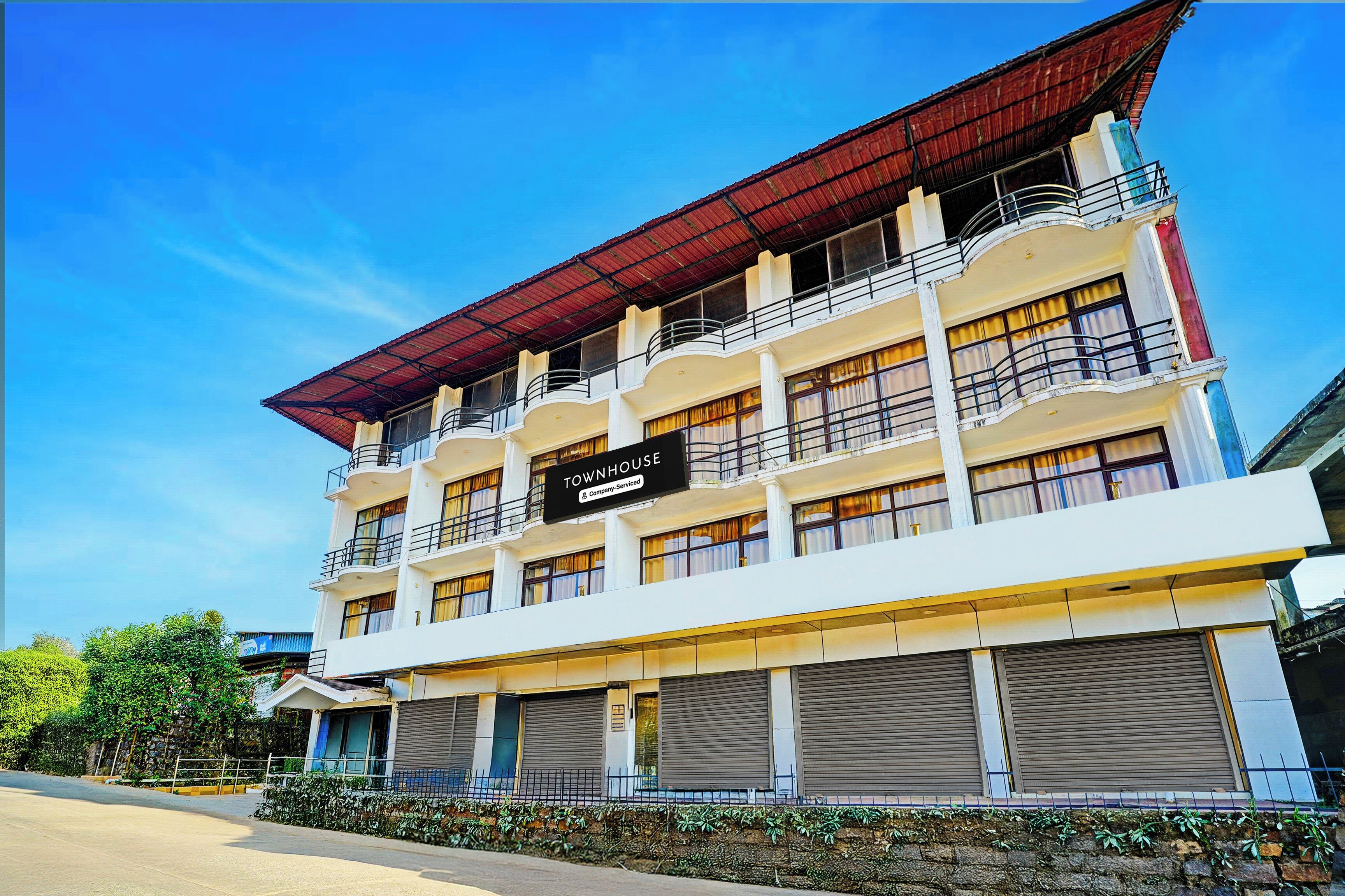 A multi-story building with a sign indicating it is a company-serviced townhouse.
