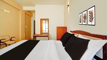 Habitación de hotel con cama, una silla, un escritorio y una puerta.