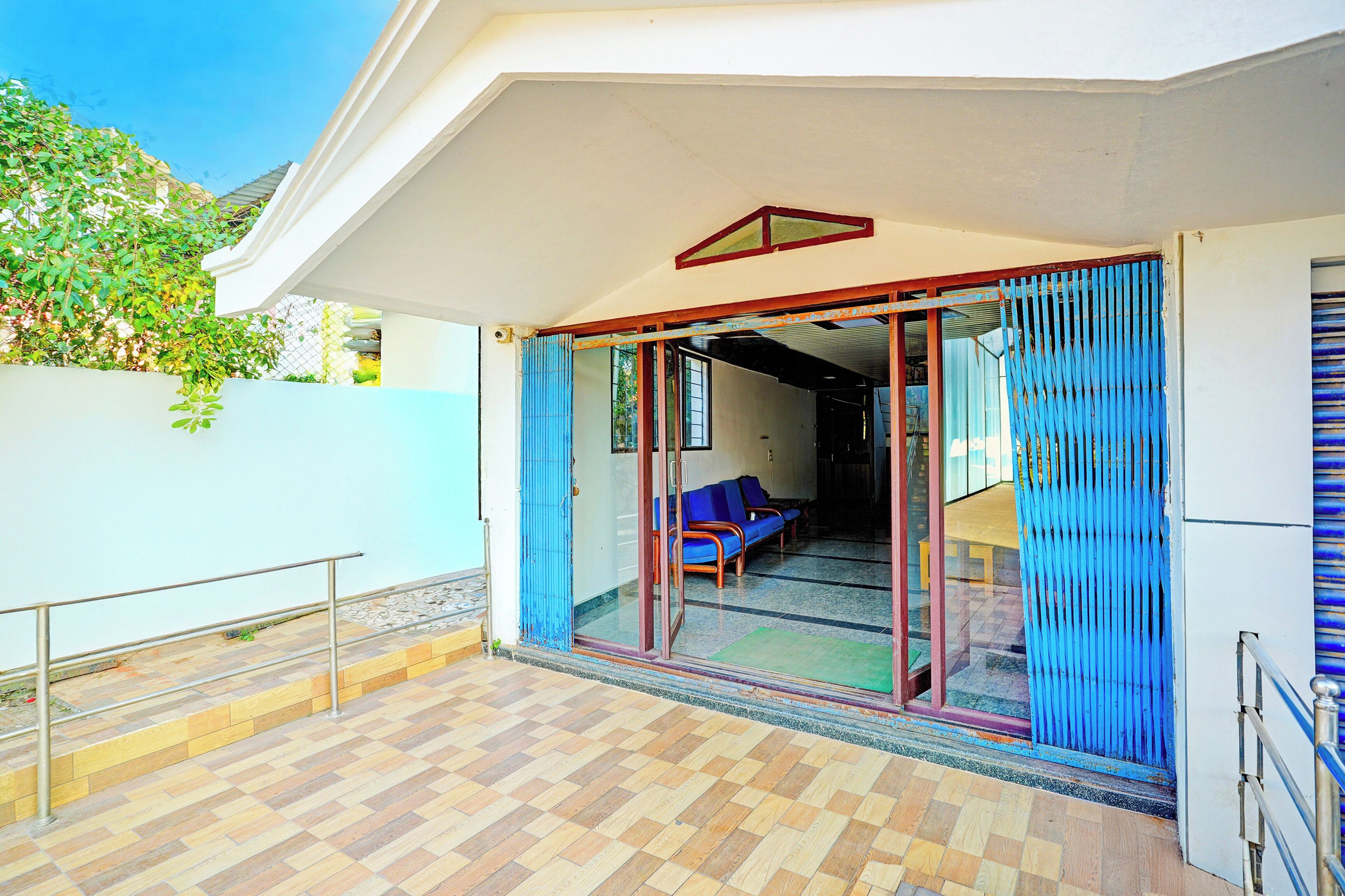A hotel room with a sliding glass door leading to a balcony, a sofa, and a small table.