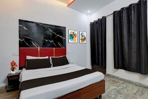 A modern hotel room with a large bed, a red headboard, abstract wall art, and a view of the outside. - Hotel O by OYO Dariya Railway Station (Chandigarh)