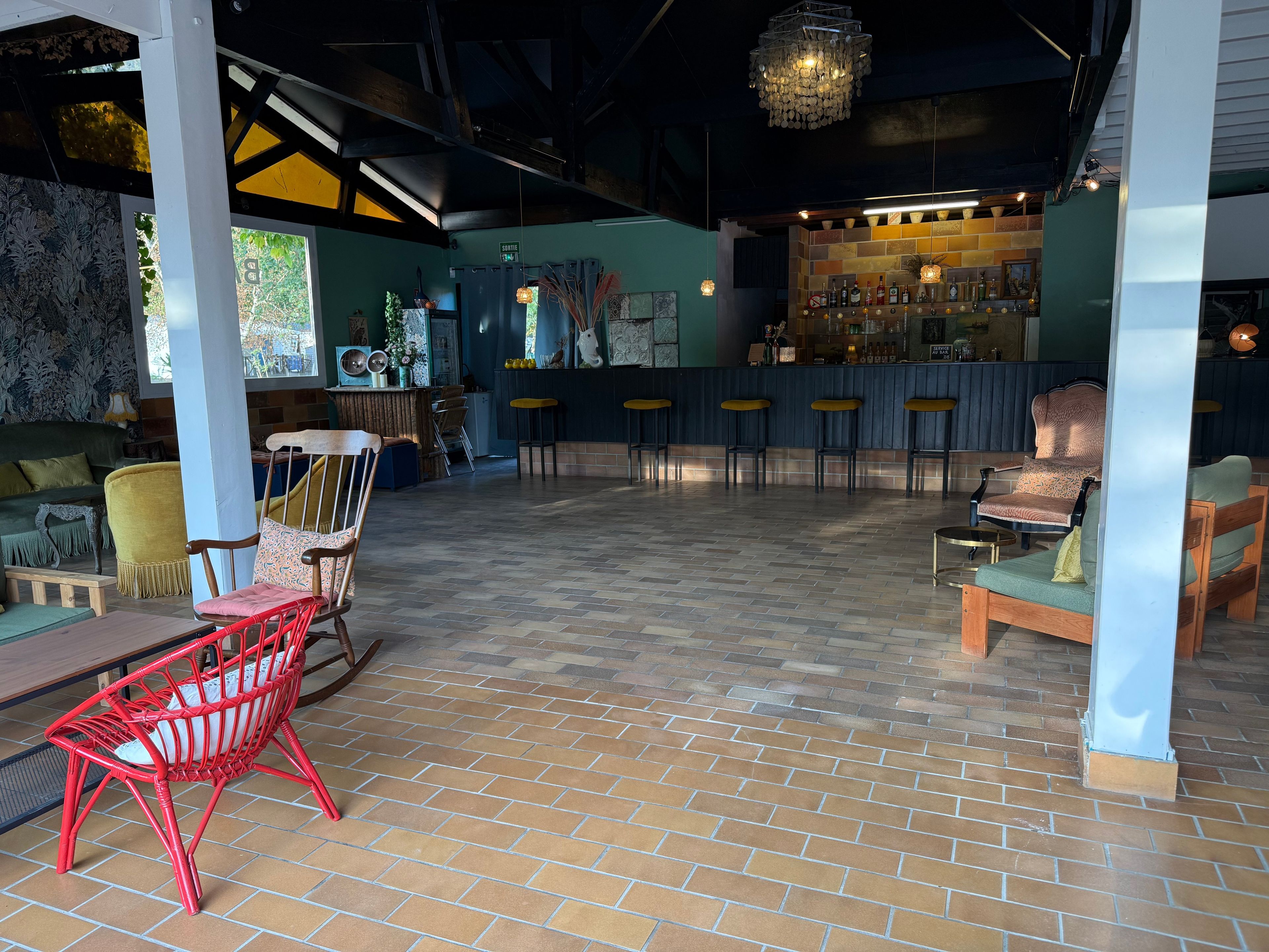 Un espace intérieur vaste et accueillant, doté d’un bar, de différents espaces pour s’asseoir et offrant une vue sur l’extérieur.