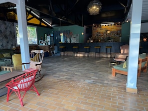 A spacious indoor area with a bar, seating arrangements, and a view of the outdoors. - Mobile Home 'Tout Confort' with Shared Pool, Wi-Fi and Air Conditioning (Hourtin)