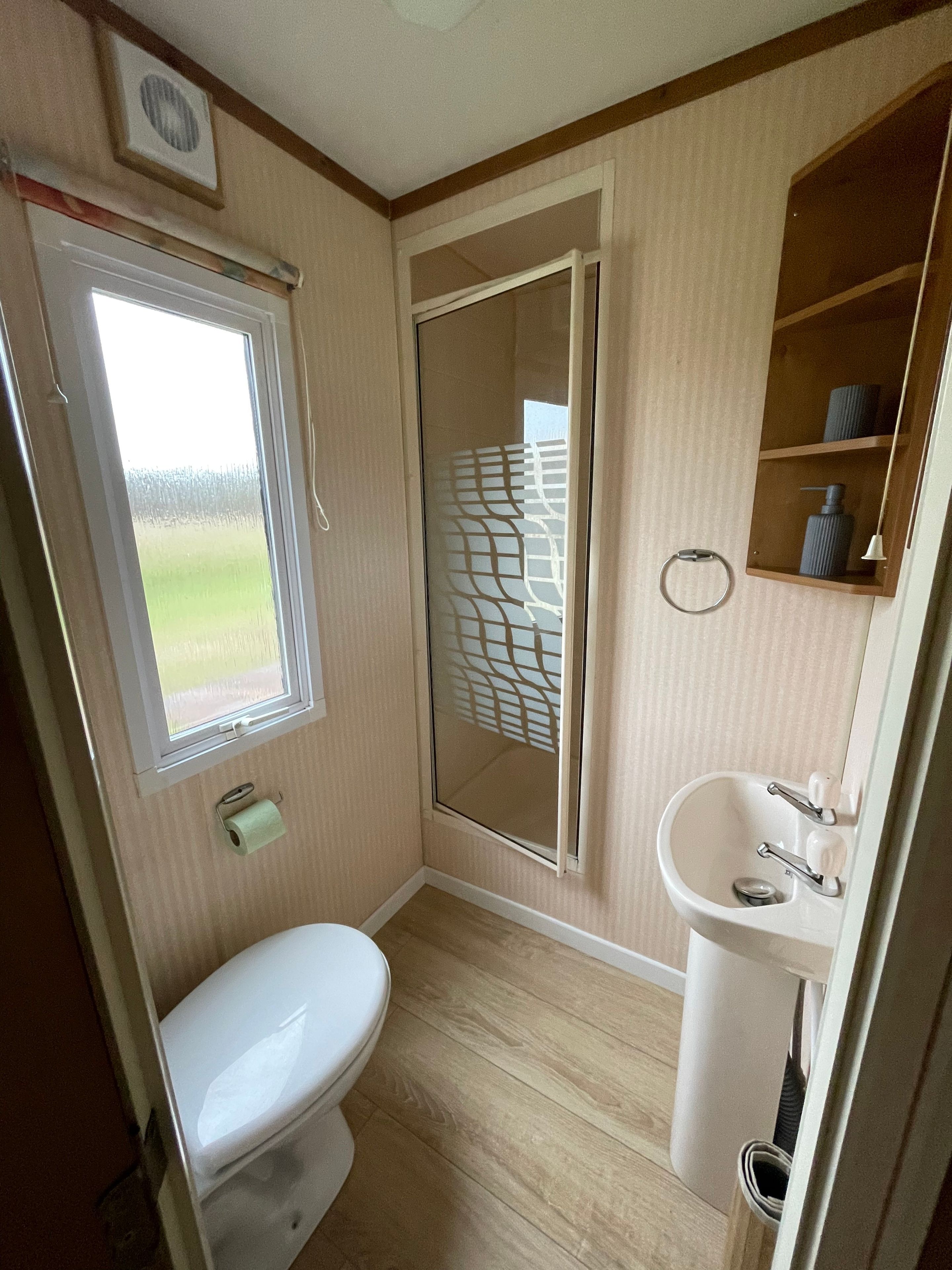 Une petite salle de bain comprenant des toilettes, un lavabo et un espace douche.