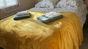 Une pièce avec un lit, une fenêtre avec des rideaux et une lampe.