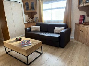 Una sala de estar moderna con un sofá, una mesa de centro y un aparador.