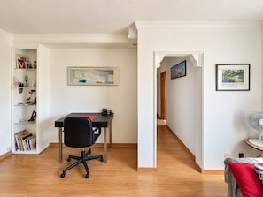 A room with a desk, chair, bookshelf, and a hallway leading to another room. - 2BR Tamarán House - Central & Quiet LPGC (Las Palmas de Gran Canaria)