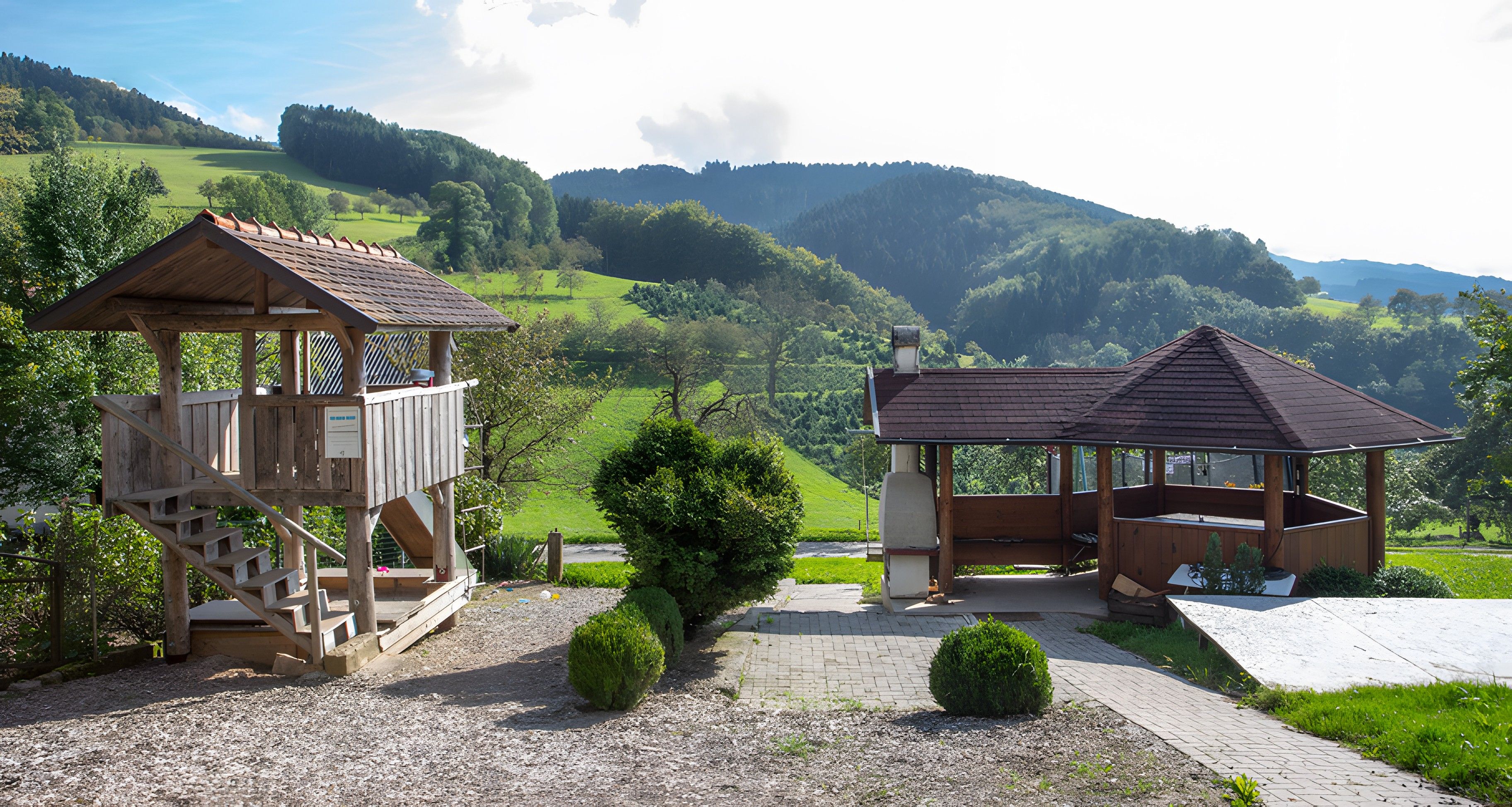 Zwei hölzerne Pavillons mit Blick auf eine hügelige Landschaft.