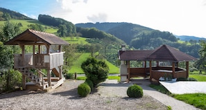 Zwei hölzerne Pavillons mit Blick auf eine hügelige Landschaft.