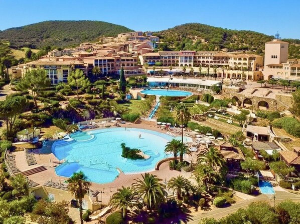 A resort with multiple swimming pools, a central courtyard, and Mediterranean-style architecture.