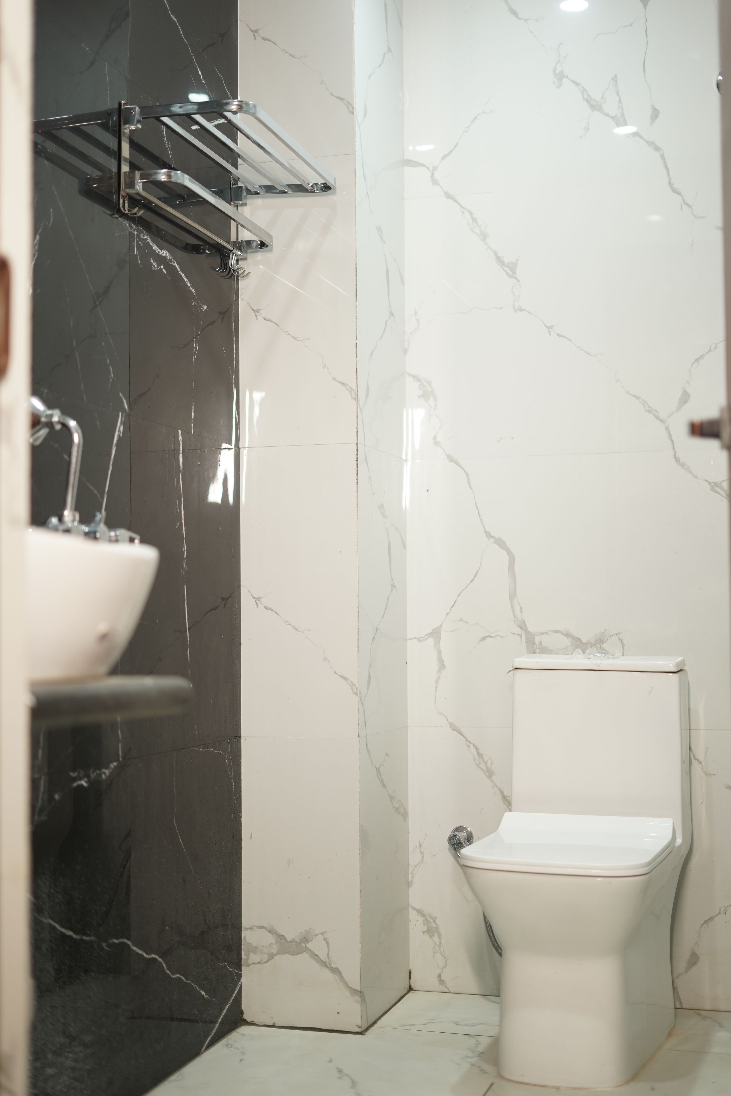 A bathroom with a white toilet, a sink, and a shower area.