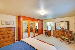 A bedroom with a bed, dresser, mirror, and a door leading to another room. - 1 Mi to Notre Dame & Dtwn: Charming Home w/ Yard (South Bend)