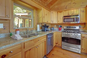 A kitchen with wooden cabinets, a stainless steel stove, a microwave, and a dishwasher. - Hot Tub, Fire Pit, Views & More: Blowing Rock Gem (Blowing Rock)
