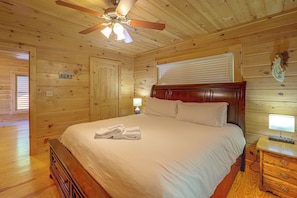 A wooden-paneled bedroom with a bed, a nightstand, a lamp, and a ceiling fan. - Hot Tub, Fire Pit, Views & More: Blowing Rock Gem (Blowing Rock)