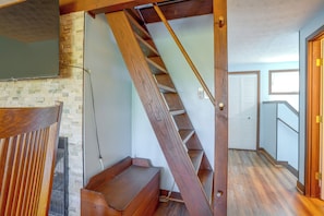 A wooden staircase with a handrail, a wall-mounted television, and a door with a sliding mechanism. - 2 Mi to Bryce Resort! All-season Condo w/ Views (Basye)