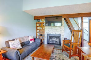 A living room with a sofa, a coffee table, a fireplace, a bookshelf, and a wooden chair. - 2 Mi to Bryce Resort! All-season Condo w/ Views (Basye)