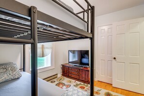 A bunk bed with a television on a wooden dresser, a patterned rug, and a white door. - 1 Mi to Colonial Beach! Coastal Escape w/ Fire Pit (Colonial Beach)