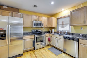 A kitchen with stainless steel appliances, wooden cabinets, and a granite countertop. - 1 Mi to Colonial Beach! Coastal Escape w/ Fire Pit (Colonial Beach)