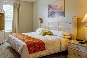 Une chambre d’hôtel avec un lit, une table de chevet, une lampe et un tableau au mur.