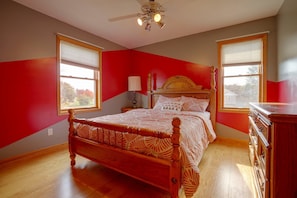 A bedroom with a wooden bed, a nightstand, a dresser, and a ceiling fan. - Northfield Home Near Nerstrand Big Woods (Northfield)