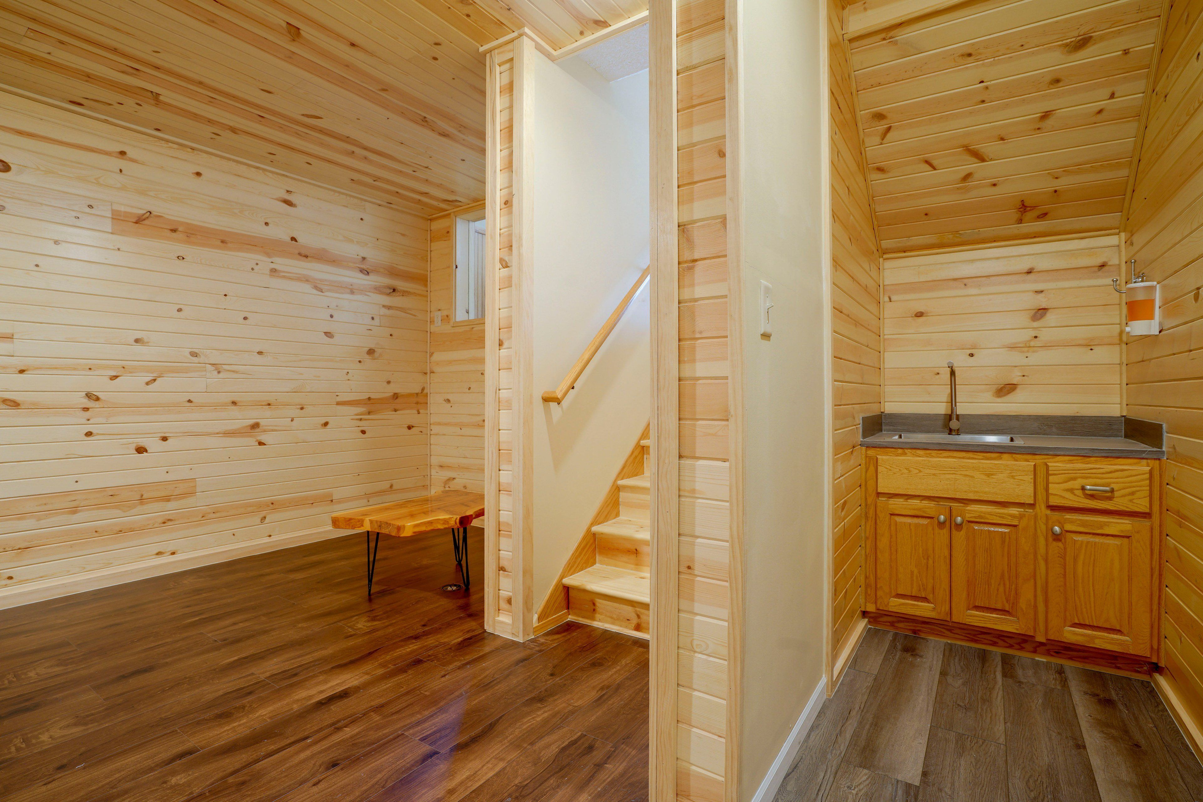 A wooden interior with a staircase leading to a kitchen area.