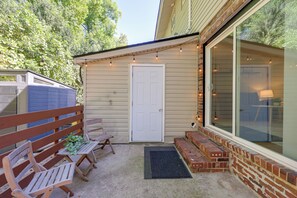 A covered patio area with a wooden bench, a small table, and a door leading to a glass-enclosed room. - 6 Mi to the Masters: North Augusta Condo (North Augusta)