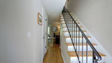 Una escalera con escalones de madera y barandillas de metal que conduce a un piso superior.