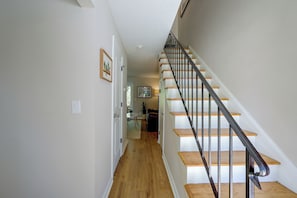 Una escalera con escalones de madera y barandillas de metal que conduce a un piso superior.