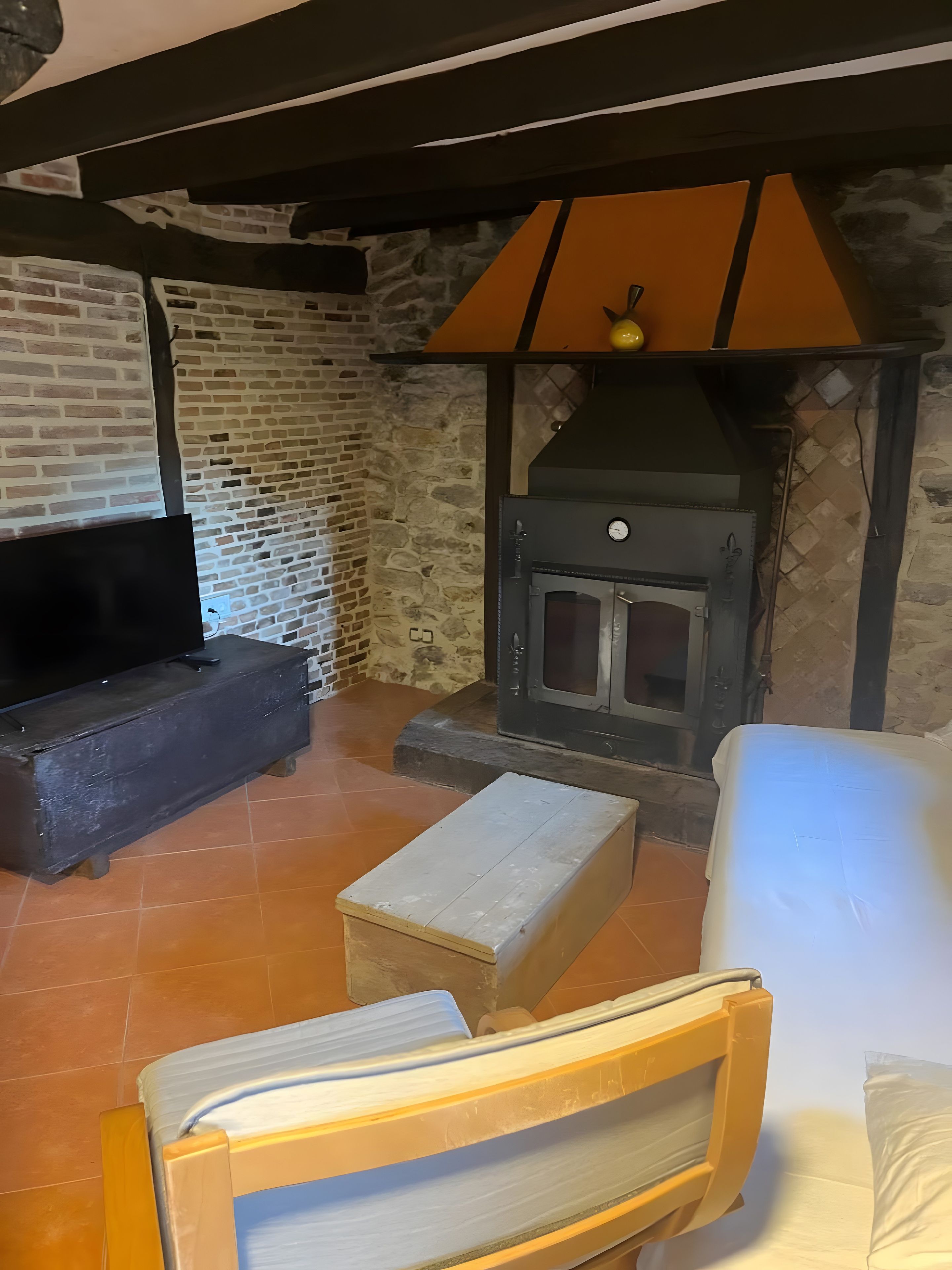 Ein rustikales Interieur mit Mauerwerk, einem Kamin und einer hölzernen Bank.