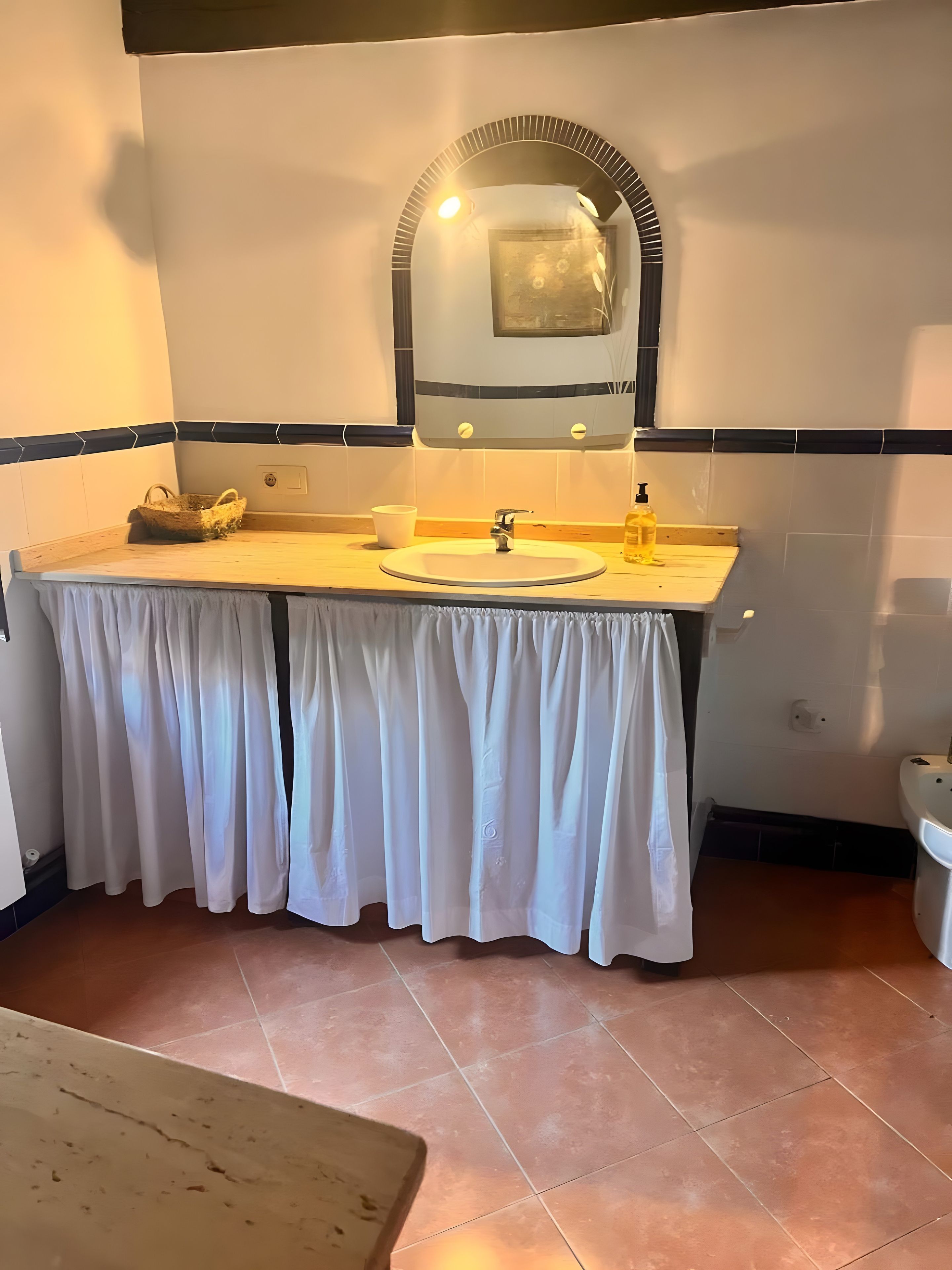 Een badkamer met een wastafel, spiegel en handdoekhouder.