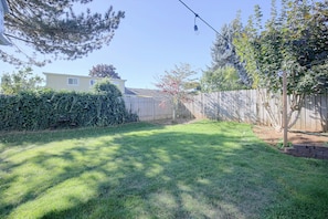 A backyard with a wooden fence, a grassy lawn, and a house in the background. - Private Hot Tub & Mtn Views! Salem Escape (Salem)