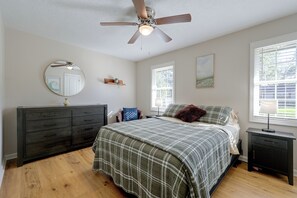 A bedroom with a bed, dresser, ceiling fan, and windows. - Duplex 6 Miles to Downtown Augusta (North Augusta)