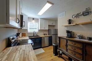 A modern kitchen with a built-in dishwasher, a stainless steel refrigerator, and a coffee station. - Duplex 6 Miles to Downtown Augusta (North Augusta)