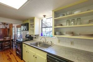 A kitchen with a built-in dishwasher, a stainless steel sink, and a window above the sink. - Fishing Cabin on Lake Bob Sandlin (Leesburg)