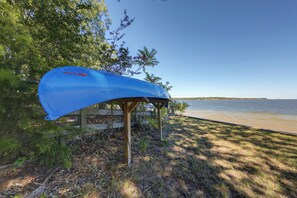 A blue kayak secured under a wooden structure by a lakeside. - Fishing Cabin on Lake Bob Sandlin (Leesburg)