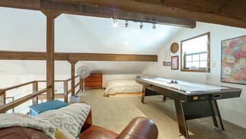 A cozy room with a loft bed, a desk, and a fan.