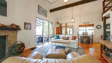 A spacious living room with a fireplace, a dining area, and a large window providing natural light.