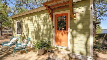 A small house with a porch, a wooden door, and a window.