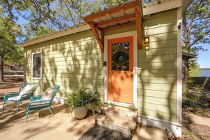 A small house with a porch, a wooden door, and a window.