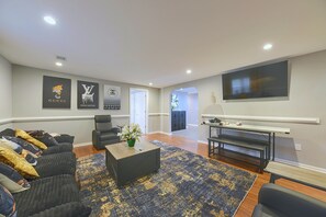 A modern living room with a sofa set, a coffee table, and a flat-screen TV mounted on the wall. - Hidden Orangeburg Gem! Spacious Modern Deco Ranch (Orangeburg)