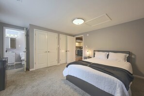 Un dormitorio con cama, vestidor y baño completo.