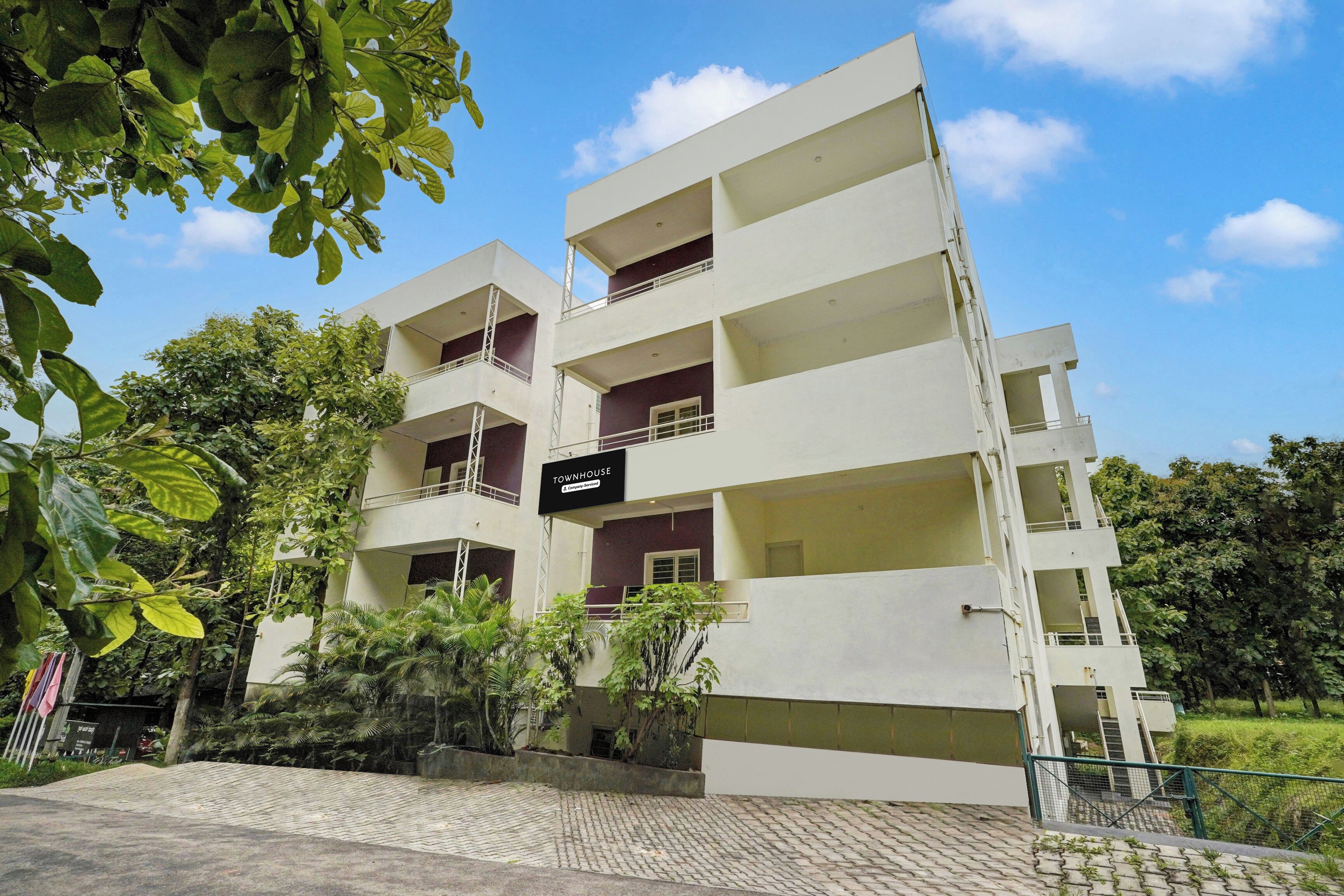 A multi-story residential building with balconies and a sign indicating it is a company service.