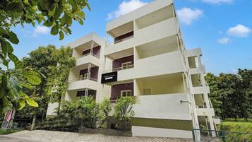 A multi-story residential building with balconies and a sign indicating it is a company service.