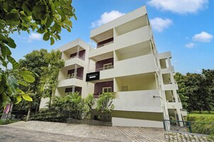 A multi-story residential building with balconies and a sign indicating it is a company service.