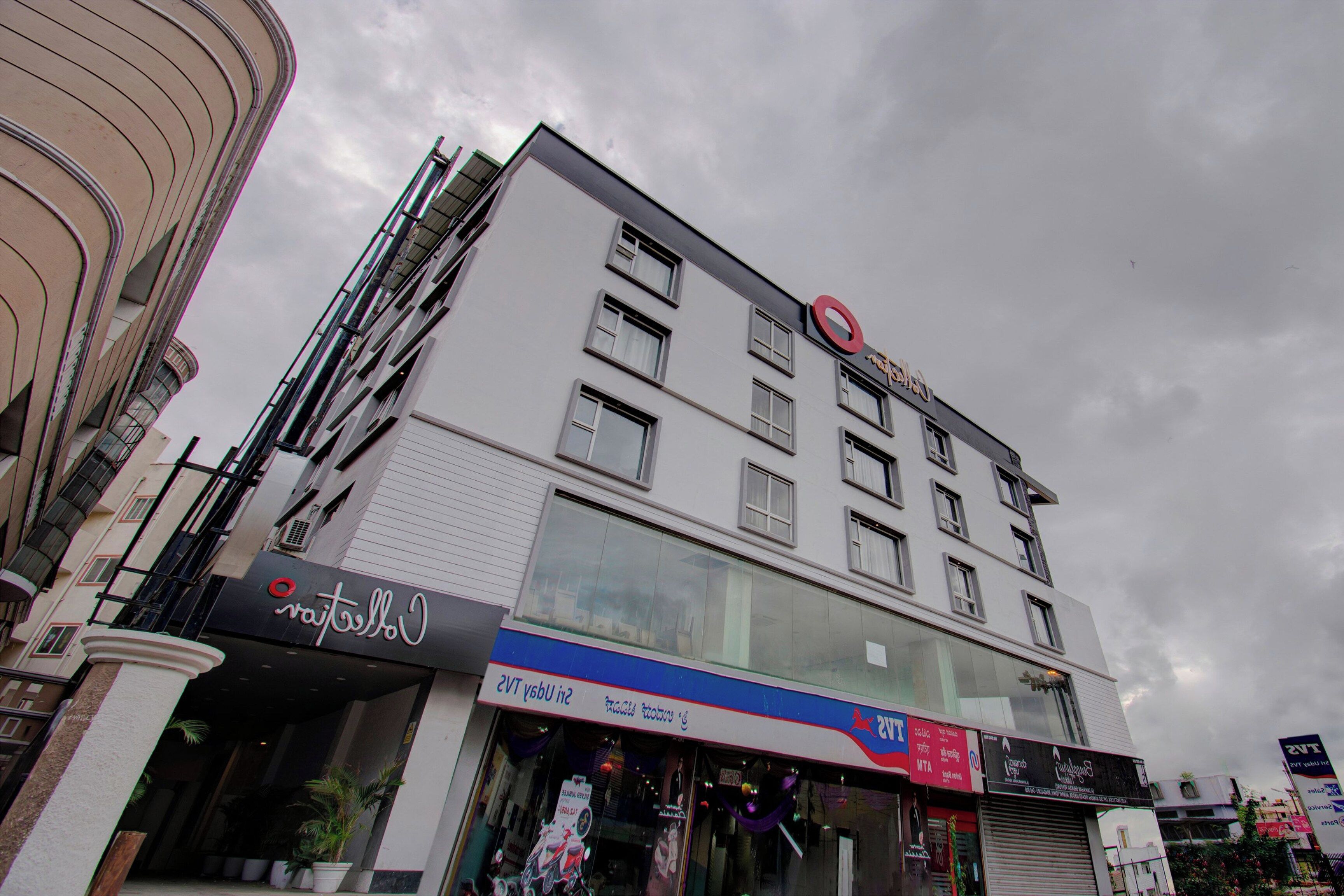 Un edificio de varios pisos con un logotipo circular rojo llamativo en la parte superior.