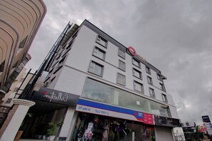 Un edificio de varios pisos con un logotipo circular rojo llamativo en la parte superior.