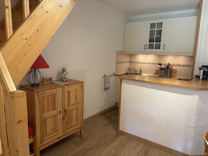 Eine Küche mit Holzschränken, einer Holzauskładung, einem Spülbecken und einer roten Lampe.