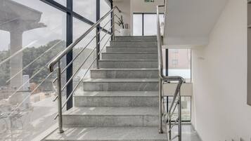 Una escalera con barandillas de metal que sube a un nivel superior.